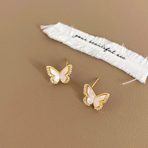 Detail of butterfly stud earrings with white mother of pearl and micro-pave crystals