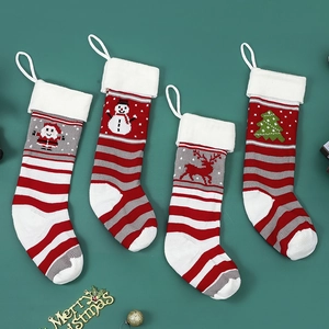Knitted Christmas stockings with Santa, Reindeer and Snowman patterns on green background
