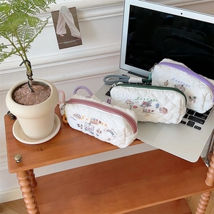 Close-up of quilted cotton pencil cases with cute animal embroidery and colorful zippers
