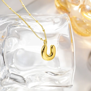Dettaglio della collana placcata oro 18K con ciondolo a lettera U e catena a sfere