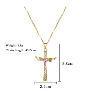 Detail of gold wing cross necklace with pink heart gem and size measurement labels
