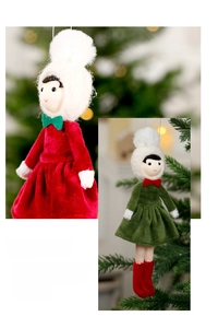 Detail of plush Christmas doll ornaments with velvet dresses hanging on a festive tree