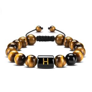 Macro shot of 10mm tiger eye beads bracelet with a black square bead featuring the letter H