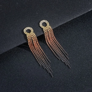 Macro shot of long gradient rhinestone tassel earrings on a sleek black background