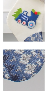 Detail of beige knitted Christmas stocking with felt blue train and textured pattern