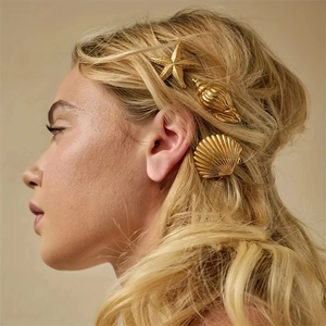 Gold ocean themed starfish shell hair clips shown on blonde hair for vacation style