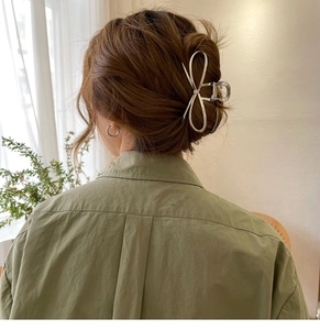 Silver bow metal hair claw clip shown from behind on a woman's elegant updo