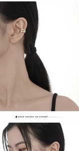 Dettaglio dell'orecchino a clip in argento S925 bicolore con texture irregolare