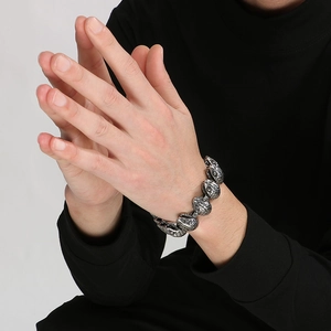 Macro shot of punk style stainless steel snake head bracelet worn on hands