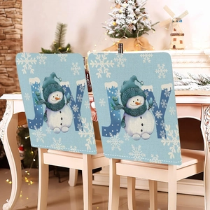 Detail view of festive blue linen chair covers with snowman and JOY text in Christmas decor