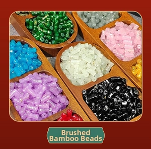 Detail view of colorful brushed bamboo-shaped beads in a wooden organizer tray
