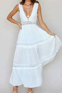 Detail of white boho maxi dress featuring intricate lace cutouts and a deep V-neckline
