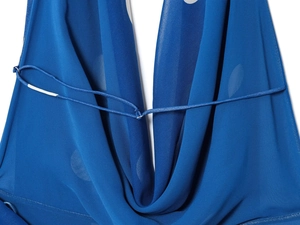 Détail de la robe bleue à pois avec dos nu licou et finitions soignées sur le tissu