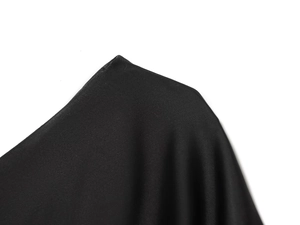 Detail of smooth black satin fabric on asymmetrical lace top shoulder and neckline
