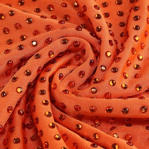 Gros plan détaillé de strass orange sur un tissu plissé de luxe pour robes