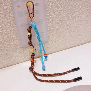 Détail du porte-clés en corde tressée avec mousqueton doré et charm mignon accessoire