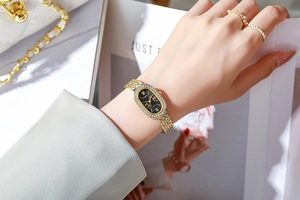 Détail de montre dorée élégante pour femme avec lunette diamant et cadran noir romain