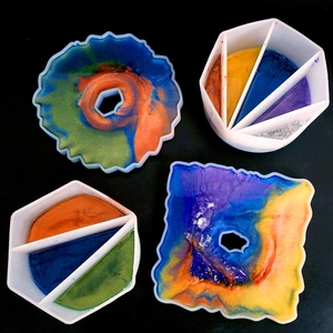 DIY resin silicone mold set with mixing cups and irregular tray molds on black background