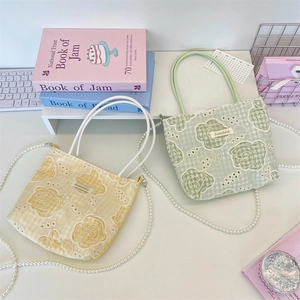 Détail des sacs à main à carreaux avec broderie en dentelle florale et chaînes perlées