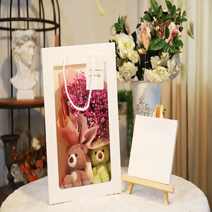 Gift bag with dried flowers and teddy bears in a white windowed presentation tote