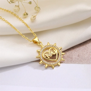 Close-up of golden sunburst heart pendant with M engraving and sparkling small diamonds