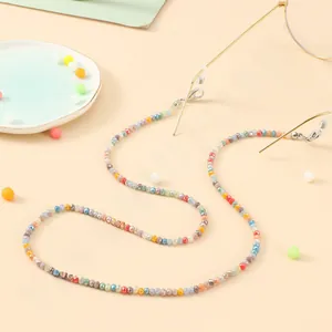 Detail showing colorful beaded eyewear chain with golden metal clips and silicone loops