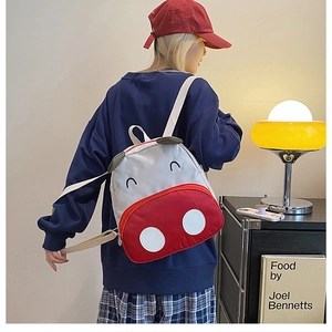 Close-up of cute cartoon ox toddler backpack with vibrant red and white canvas texture