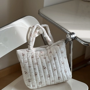Close-up of white quilted tote bag with cute animal prints and simple wish label
