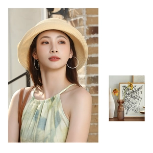 Détail d'un chapeau de paille chic avec boucles d'oreilles et robe d'été tie-dye