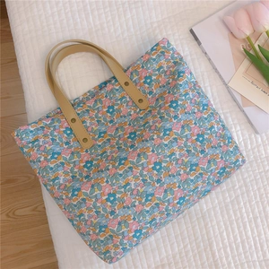 Detail view of floral tote bag with bronze rivets and stylish tulip background decoration