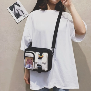 Detail of canvas crossbody bag with rainbow patch and cartoon card insert on model