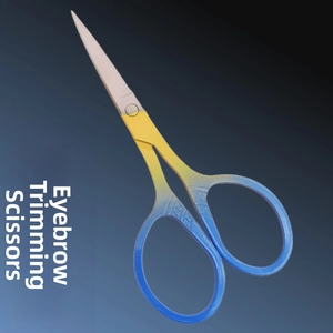 Macro detail of eyebrow scissors featuring blue yellow gradient handle and non-slip texture