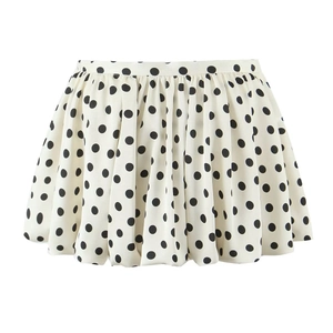 Detail eines cremefarbenen Chiffon-Plisseerocks mit großem schwarzen Polka-Dot-Muster