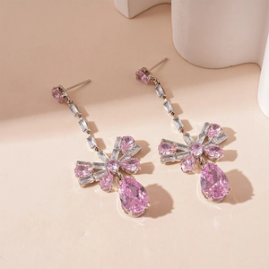 Detail of elegant silver drop earrings featuring pink zircon bow and teardrop stones
