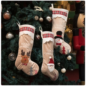 Three-pack Christmas stockings with reindeer, Santa, and snowman embroidery on a tree