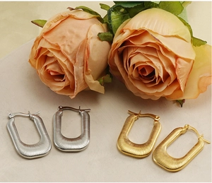 Macro view of gold and silver U-shaped earrings with fine radial ribbed texture detail