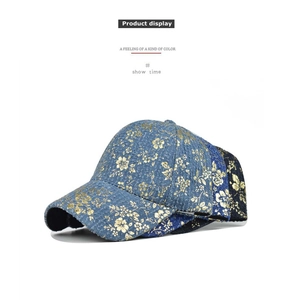 Close-up of floral gold embroidery on high-quality blue and black hip-hop baseball caps