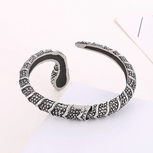 Detail of vintage stainless steel snake bangle with textured scales and open adjustable cuff