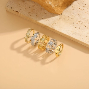 Detailed view of set of five gold and silver rings with zircons on stone display
