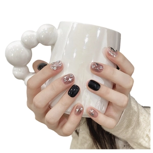 Short round black press-on nails with silver glitter, stars and sparkling rhinestones