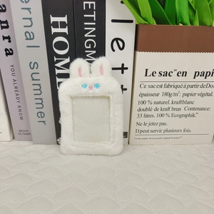 Close-up of white plush bunny ear card holder with soft texture and clear window