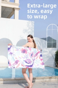 Model by the pool wrapped in a large quick-dry beach towel with marine life prints
