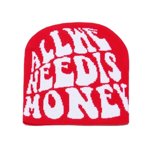 Detail of red knit beanie featuring white jacquard ALL WE NEED IS MONEY lettering