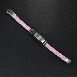 Close-up of pink braided leather bracelet with a polished silver metal engraving plate