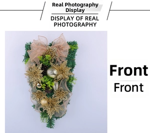 Detailaufnahme von goldenem Weihnachtsschmuck mit Poinsettien, Tannennadeln und Kugeln