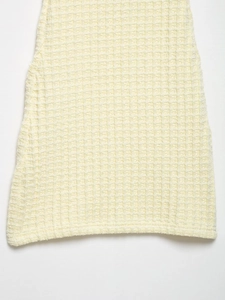 Primer plano de la textura de punto gofrado amarillo claro de un vestido de verano