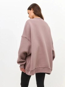 Rear view of an oversized mauve sweatshirt featuring drop shoulders and ribbed hem detail