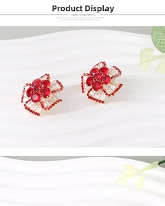 Detail of floral stud earrings with red rubies and baguette-cut diamonds on ceramic