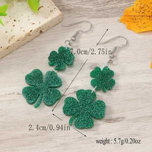 Detailed view of green shamrock earrings with dimensions 7.0cm length and glitter texture
