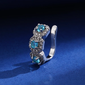 Macro detail of silver U-shaped clip-on earrings with blue zircon and pavé crystals